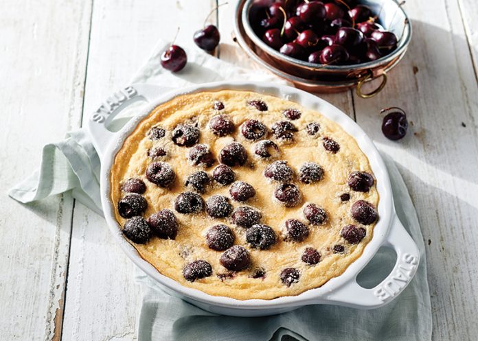 Cherry Clafoutis on white wood in white Staub cast iron