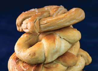 The Essential Pretzel Dough Essential Pretzel Dough recipe with shaped pretzels stacked on blue surface