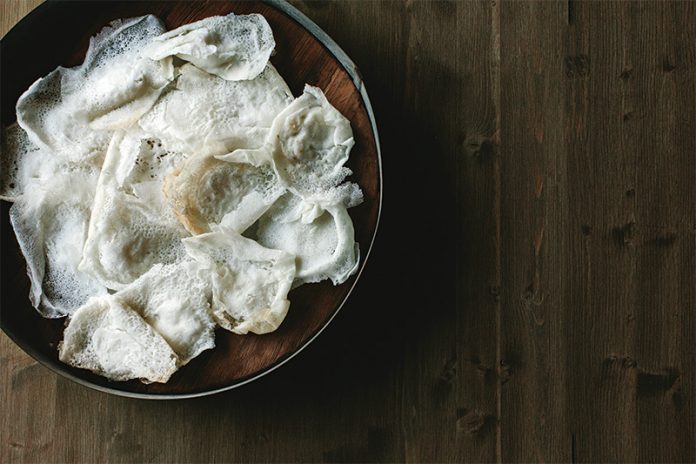 Appam in brown bowl on wooden surface
