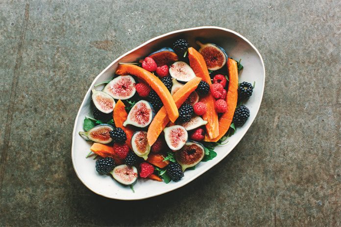 Tropical Fall Salad in a white bowl on darker surface