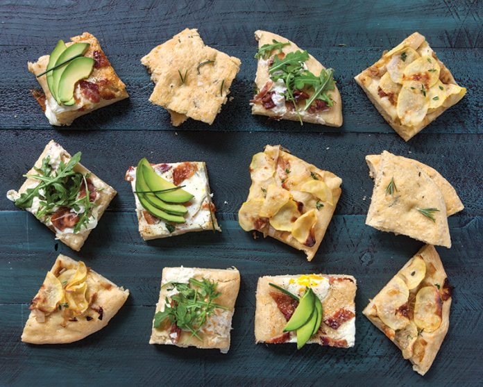 Four ways with Focaccia sliced and topped on green surface