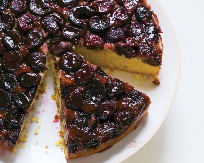 Sweet Cherry Cornmeal Upside Cake sliced on white