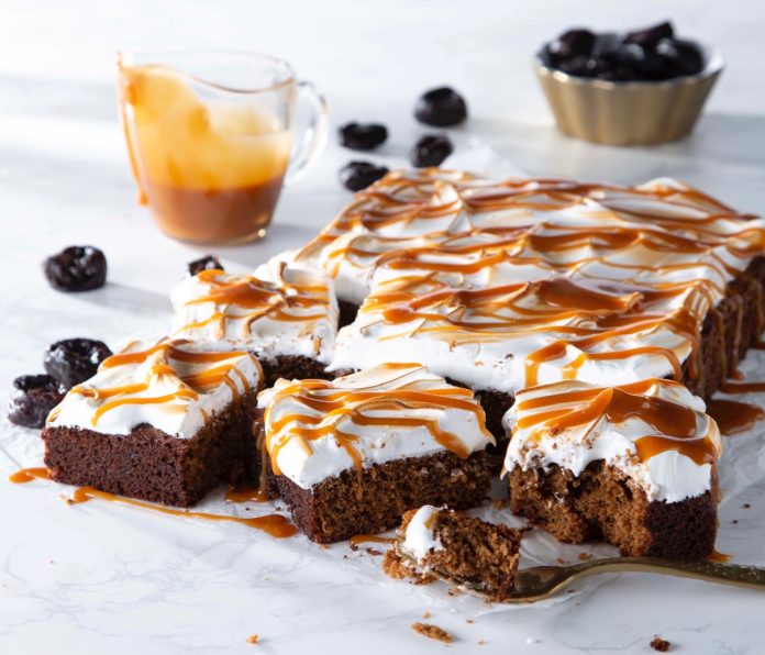Sticky Toffee Pudding Prune Squares cut on parchment with caramel drizzle