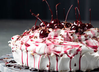 Black Forest Pavlova pavlova topped with cream and cherries