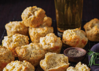 Beer-Cheddar Muffins beer-cheddar muffins in a stack next to a tall glass of lager