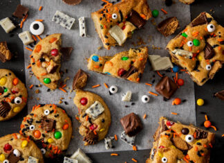 Leftover Candy Compost Cookies & Bars Leftover Candy Compost Cookies & Bars on white parchment on black surface with fun sprinkles and candy scattered on surface