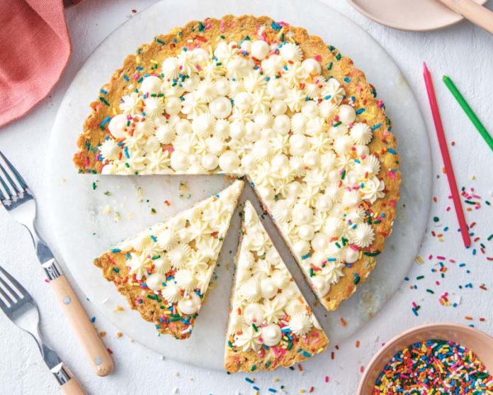 birthday pie sliced with sprinkles and colored candles on white background birthday 