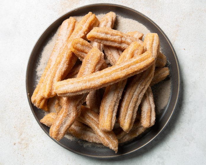Baking School In-Depth: Churros on gray plate filled with cinnamon sugar