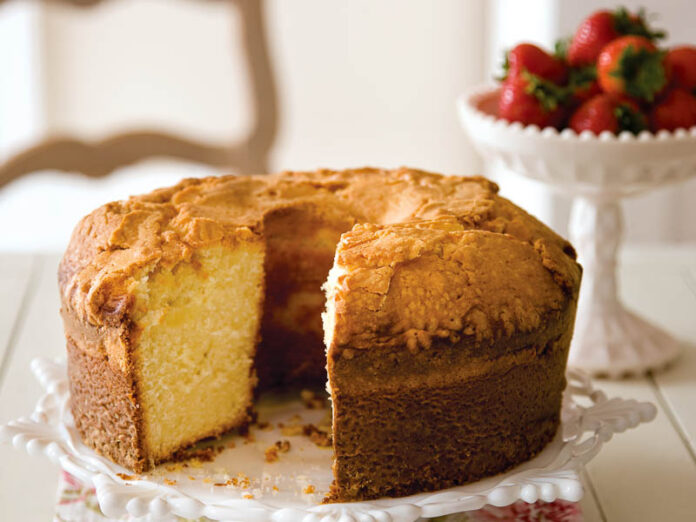 whipping cream pound cake on a plate with a bowl of strawberries