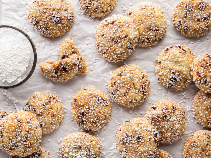 Cherry crème fraîche cookies spread out overhead on parchment