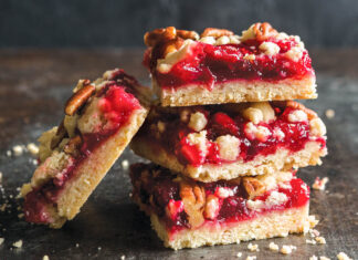 Cranberry Jam Pecan Bars cranberry jam pecan bars stacked on dark surface.