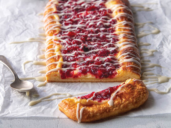 Cranberry Danish on parchment drizzled with glaze