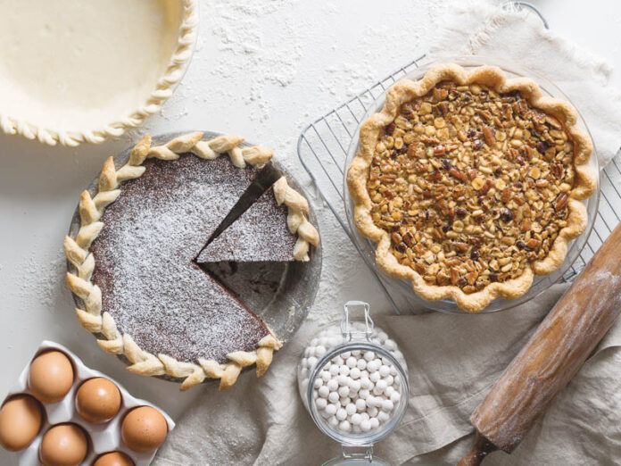 pies on white surface with ingredients surrounding