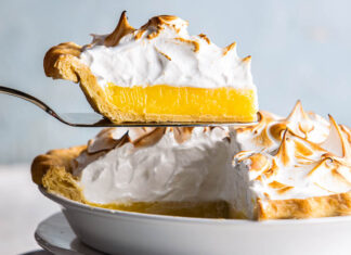 Mile-High Lemon Meringue Pie mile-high lemon meringue pie on server lifting out of pie dish.
