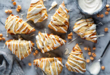 Butterscotch Scones with Vanilla Bean Glaze Butterscotch Scones with Vanilla Bean Glaze on white surface with glaze drizzled on top.
