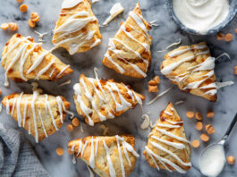 Butterscotch Scones with Vanilla Bean Glaze Butterscotch Scones with Vanilla Bean Glaze on white surface with glaze drizzled on top.