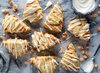 Butterscotch Scones with Vanilla Bean Glaze Butterscotch Scones with Vanilla Bean Glaze on white surface with glaze drizzled on top.