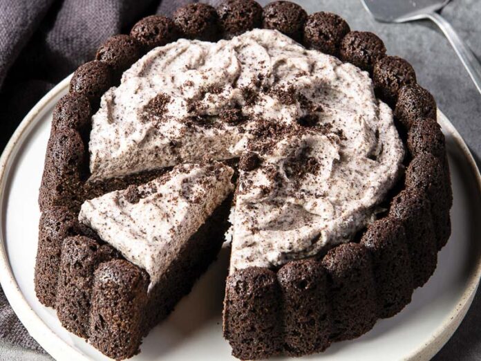 Black Cocoa Cookies and Cream Cake on White Platter with Silver Cake Slicer