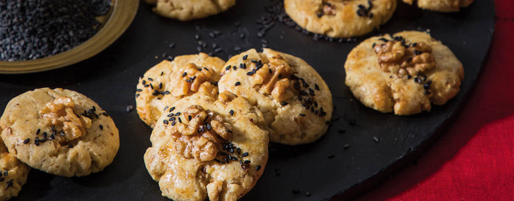 Walnut Cookies on Black Tray with Bowl of Sesame Seeds