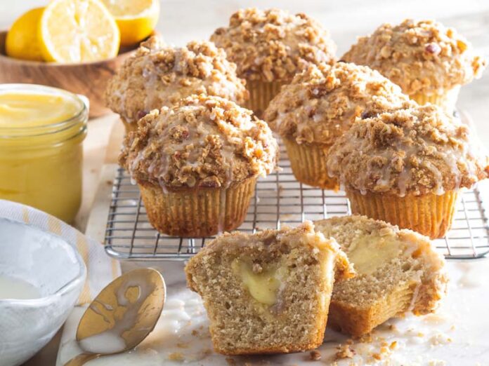 Lemon Curd Muffins on wire cooling rack with lemons and curd