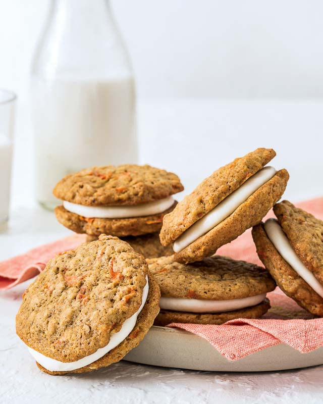 Carrot Cake Sandwich Cookies on red linen in white bowl