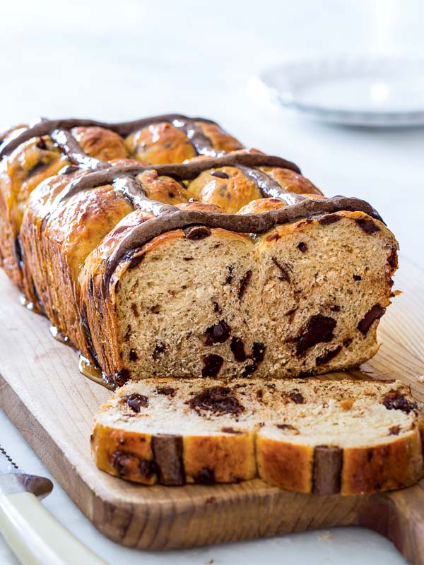 Chocolate Cherry Hot Cross Buns on wooden cutting board