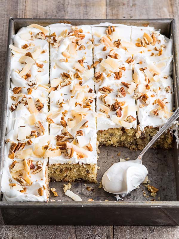 Italian Cream Sheet Cake in metal baking dish with spoon