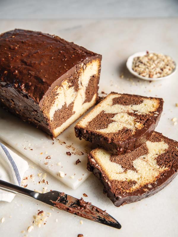 French Marble Pound Cake on marble with knife and bowl of hazelnuts